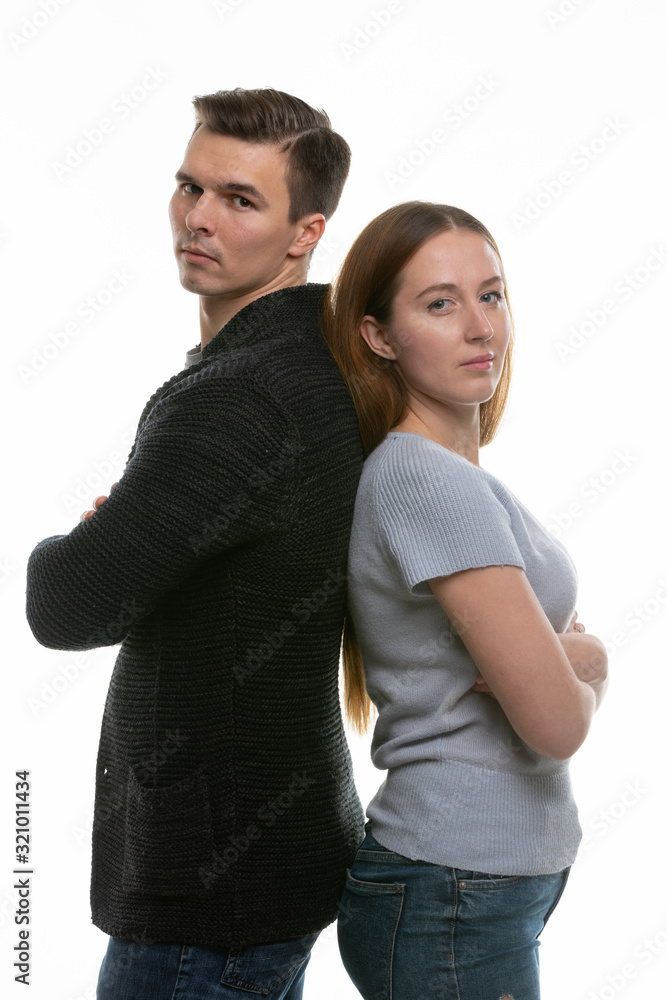 A couple with big problems stand with their backs to each other and look into the frame A couple with big problems stand with their backs to each other and look into the frame