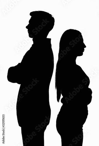 A silhouetted contoured black white portrait of a young couple standing with their backs to each other