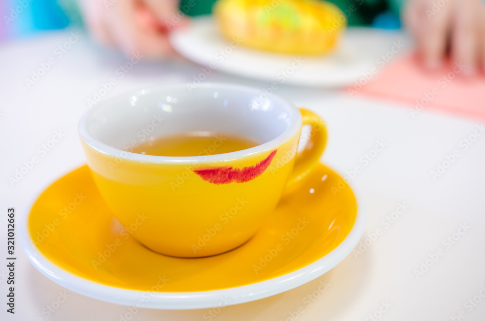 Red lipstick track on the yellow cup Red lipstick track on the yellow cup
