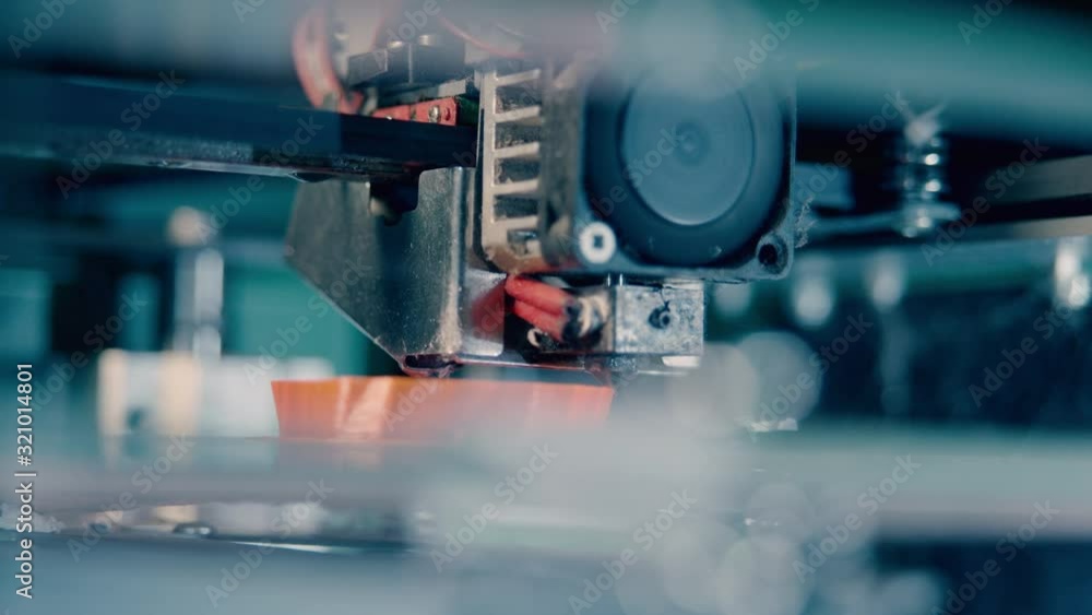 Three dimensional 3d printer working at 3d printing lab. Head of a 3D-printer at work in a close up Three dimensional 3d printer working at 3d printing lab. Head of a 3D-printer at work in a close up