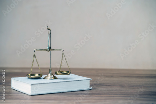 Law scales on wooden desk concept for justice and equality photo