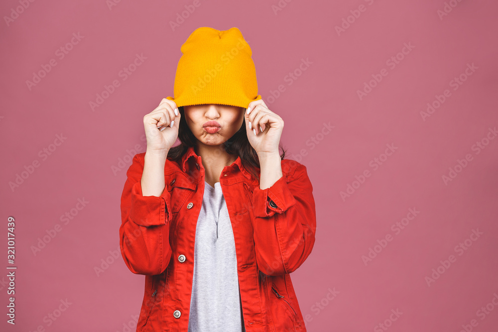 Portrait of happy young hipster woman in yellow hat and red shirt isolated over pink background. Portrait of happy young hipster woman in yellow hat and red shirt isolated over pink background.