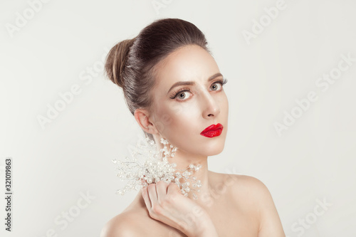Shining like pearls. Beauty Fashion Model Girl with full makeup red black gradient lips nails holding pearls jewelry looking at you camera light smile isolated white light grey background. Studio shot