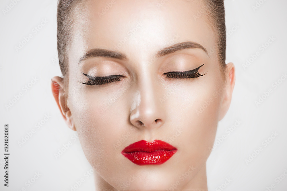 Just beautiful. Close up of a gorgeous woman red lips, black long eyelashes clean skin eyes closed isolated on a white background wall Just beautiful. Close up of a gorgeous woman red lips, black long eyelashes clean skin eyes closed isolated on a white background wall