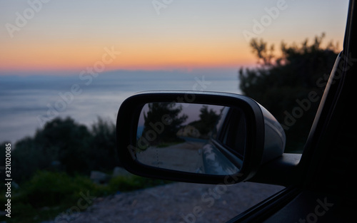 A view from a car window at sunset over the sea