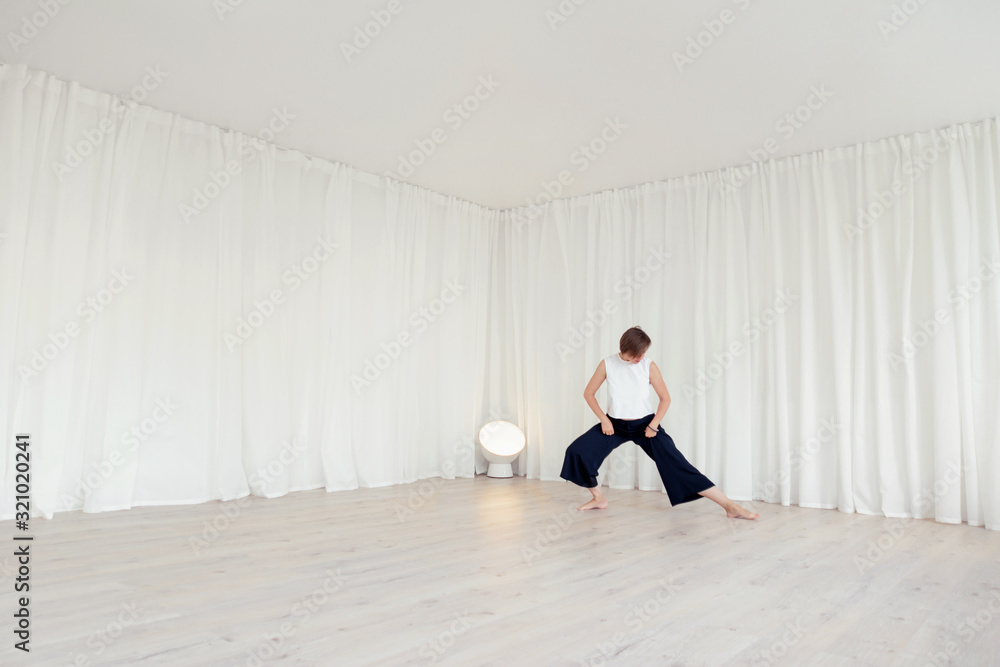 Fototapeta premium Woman doing exercises in a white room