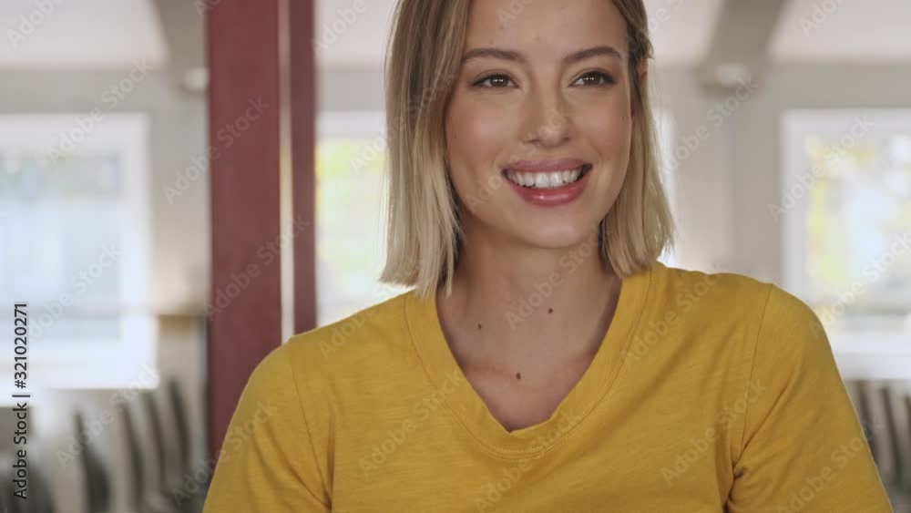 A happy smiling woman is using a phone in a conference hall while camera is moving from one side to another A happy smiling woman is using a phone in a conference hall while camera is moving from one side to another