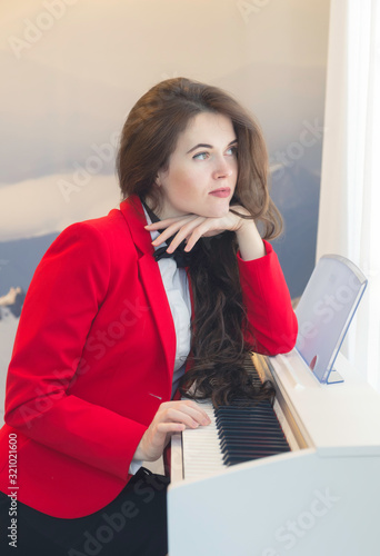 Young beautiful woman playing the piano at home