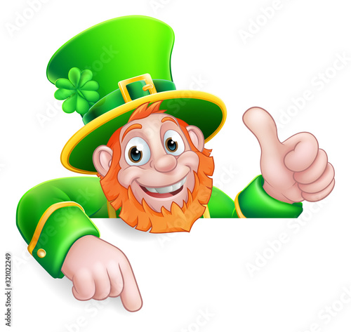 A Leprechaun St Patricks Day cartoon character giving a thumbs up, peeking over a sign and pointing at it