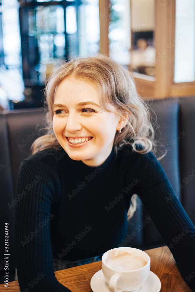 The girl in the cafe, a student or a Manager, meeting with friends in cafes, coffee, and coffee break The girl in the cafe, a student or a Manager, meeting with friends in cafes, coffee, and coffee break