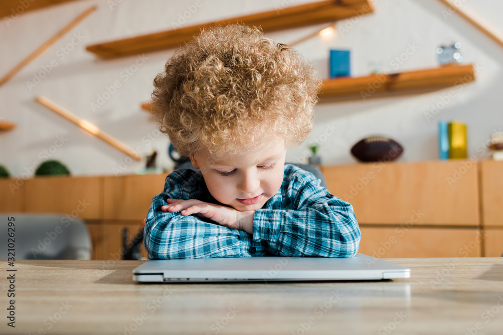 pensive kid looking at laptop at home pensive kid looking at laptop at home