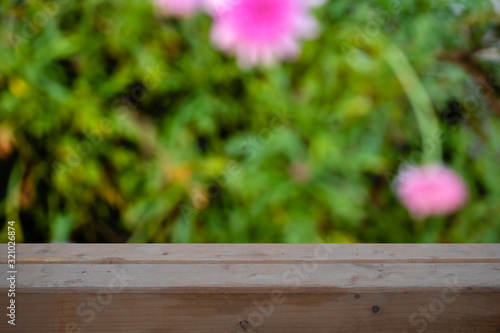 Wood table top on blurred green background - can be used for montage or display your products © solipa