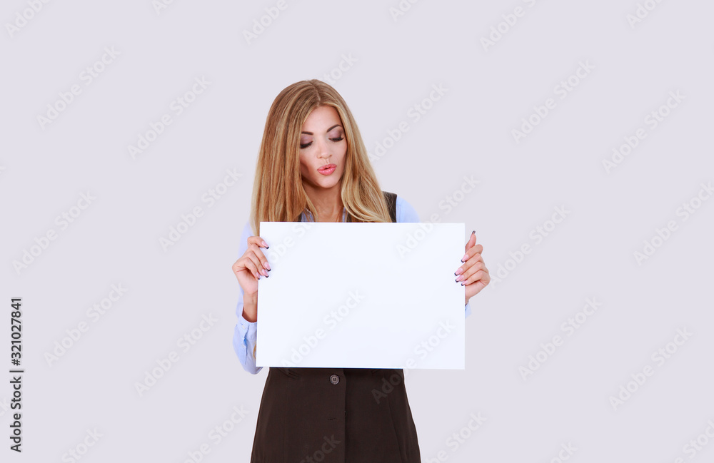Business girl surprised looking down holding a clean sheet of paper blank banner. Write your text advertise your services. isolated light purple white background. Positive face expression emotion. Business girl surprised looking down holding a clean sheet of paper blank banner. Write your text advertise your services. isolated light purple white background. Positive face expression emotion.