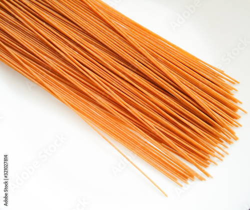 raw whole wheat pasta on white background