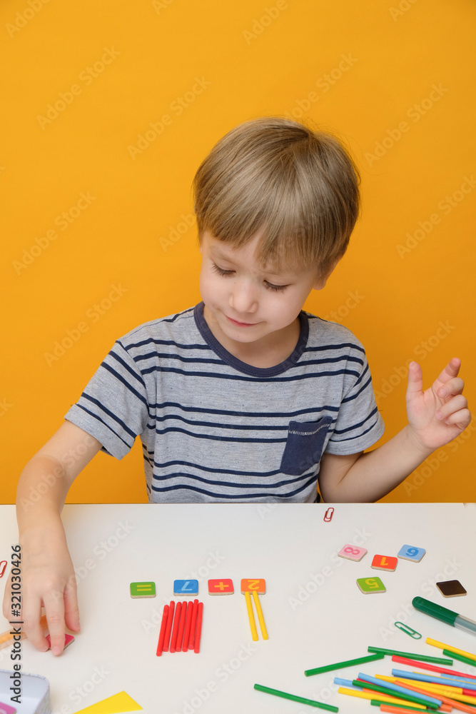Little boy preparing for elementary school doing simple math exercises Little boy preparing for elementary school doing simple math exercises