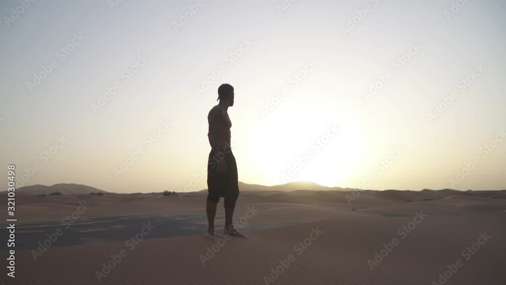 man climbing a dune in the sahara desert man climbing a dune in the sahara desert