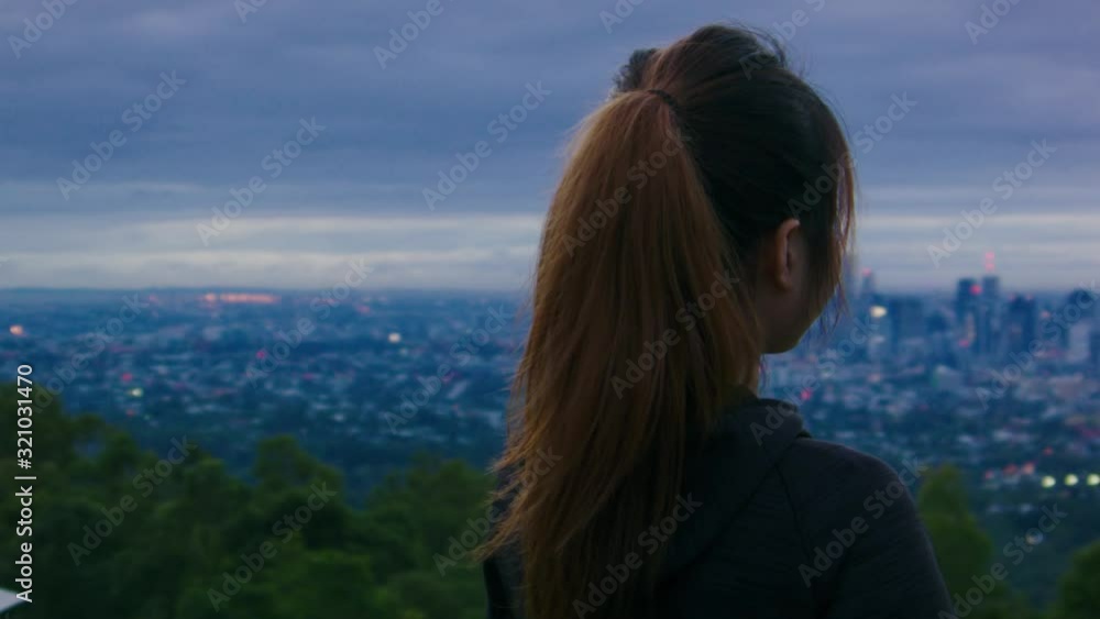 Back view of girl observing panoramic view of Brisbane city from Mount Coot-tha Summit Circuit.