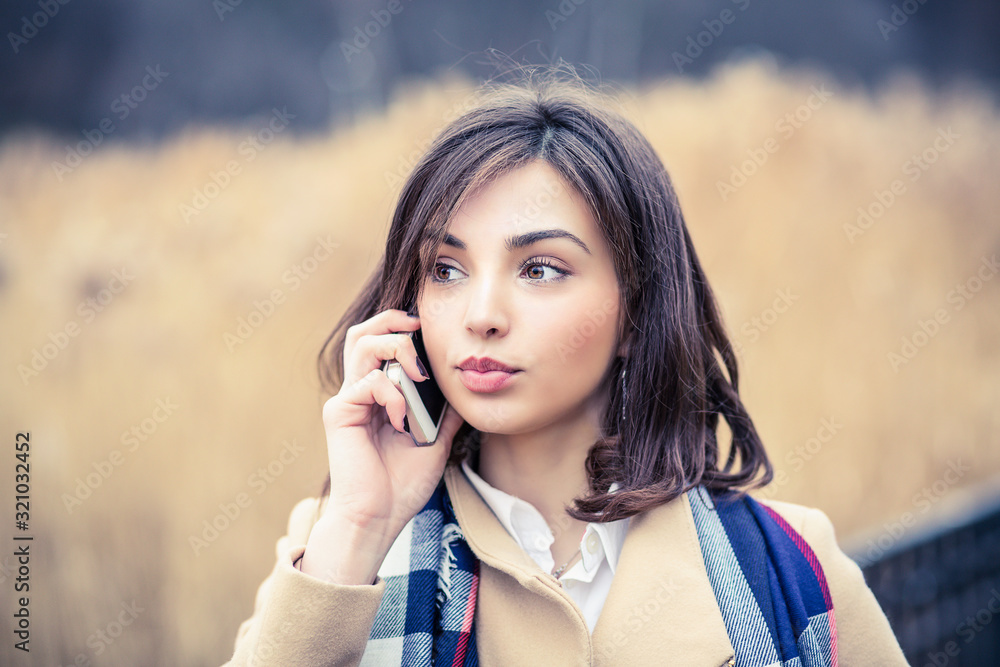 Phone talk. Closeup portrait. Serious woman talking on mobile phone outside outdoors on autumn park background, professional conversation, smart business people concept Phone talk. Closeup portrait. Serious woman talking on mobile phone outside outdoors on autumn park background, professional conversation, smart business people concept