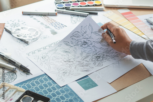 Designer designing drawing sketch pattern geometric flower seamless wallpaper fabric textile fashion industry. artistic design studio..