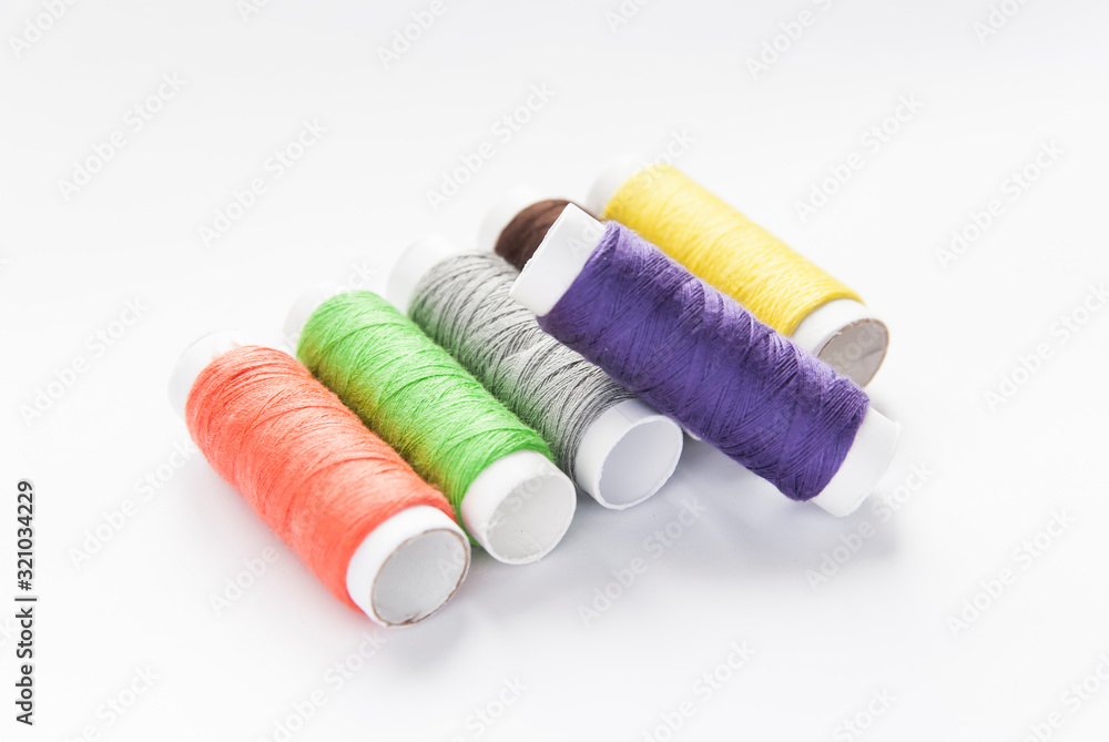 colorful spools of thread close-up on a white background colorful spools of thread close-up on a white background