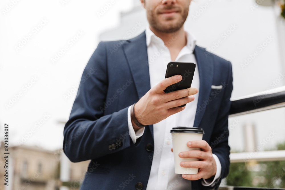 Handsome young bearded businessman standing outdoors Handsome young bearded businessman standing outdoors