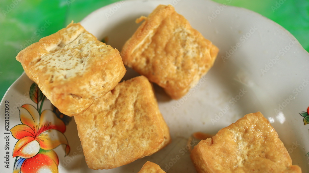 Blurred image out of focus fried tofu on a white plate, photographed with selective focus Blurred image out of focus fried tofu on a white plate, photographed with selective focus