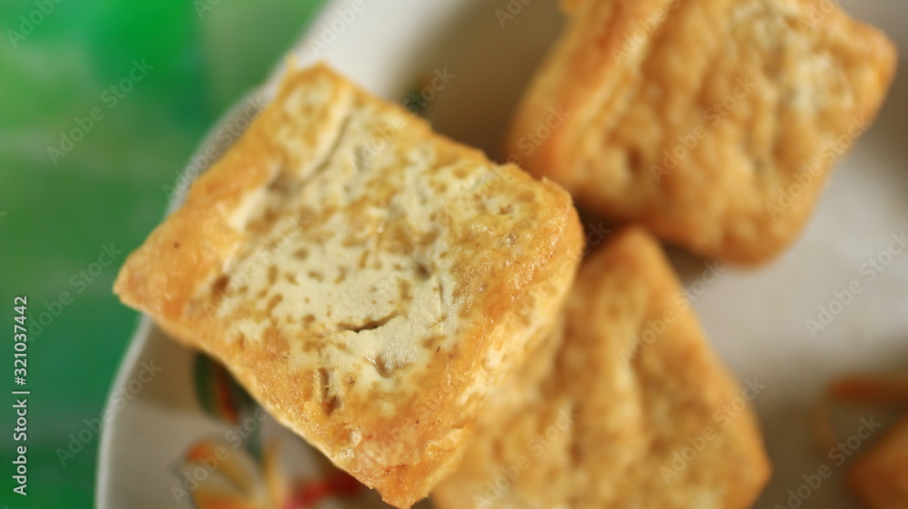 Blurred image out of focus fried tofu on a white plate, photographed with selective focus Blurred image out of focus fried tofu on a white plate, photographed with selective focus