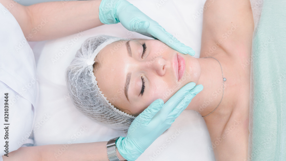 The female dermatologist do face massaged to beautiful girl cosmetology cabinet or beauty clinic. The female dermatologist do face massaged to beautiful girl cosmetology cabinet or beauty clinic.