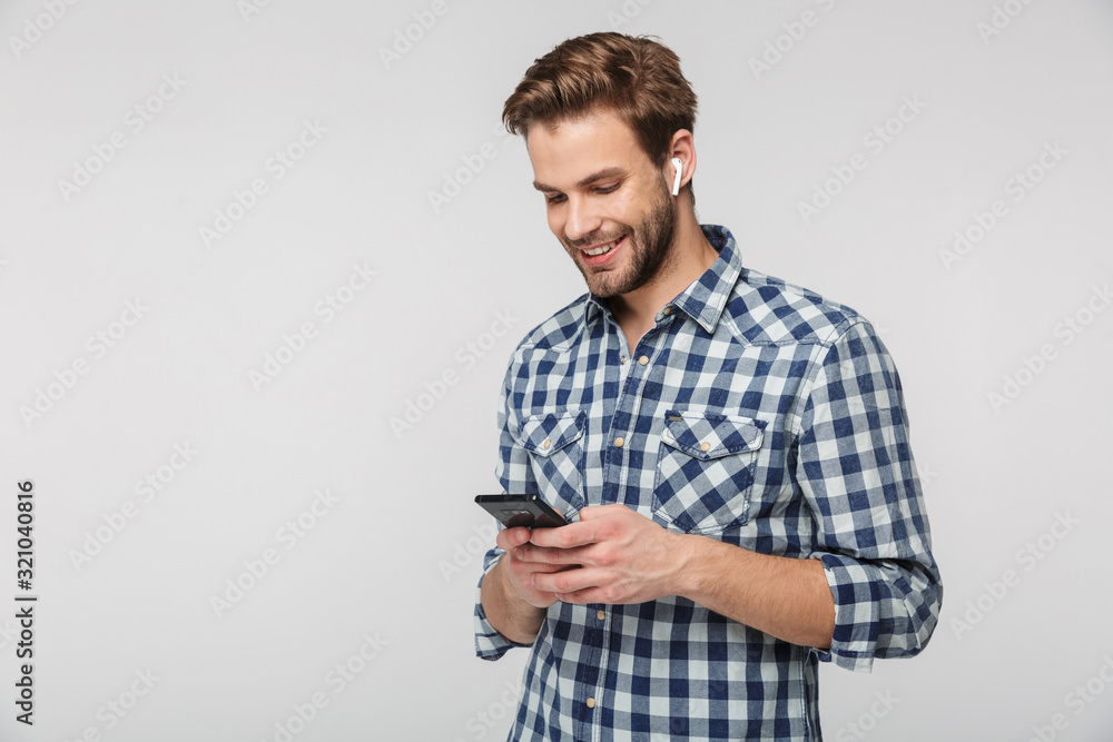 Portrait of happy young man using cellphone and earphones Portrait of happy young man using cellphone and earphones
