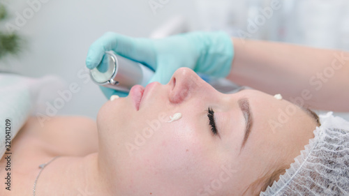 The female dermatologist do face massaged to beautiful girl cosmetology cabinet or beauty clinic.