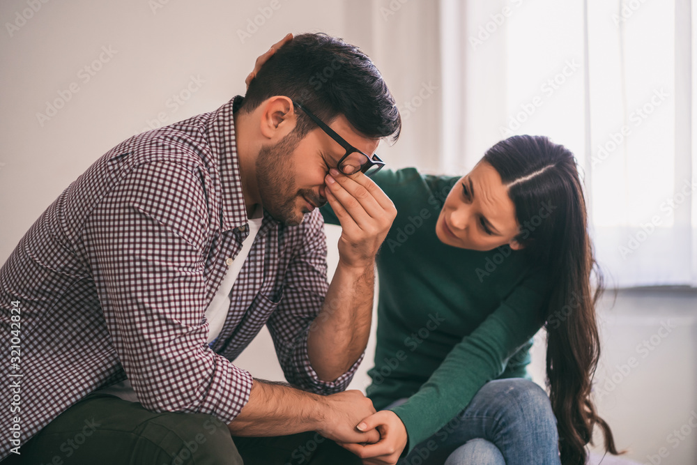 Man is sad and depressed, his wife is consoling him. Man is sad and depressed, his wife is consoling him.