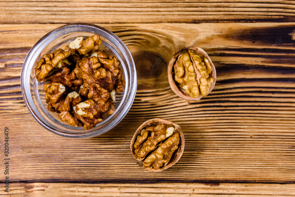 Cores of walnut in glass bowl on a wooden table. Top view Cores of walnut in glass bowl on a wooden table. Top view