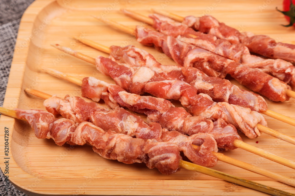 Fresh slices of raw mutton are strung with bamboo sticks and placed on plates