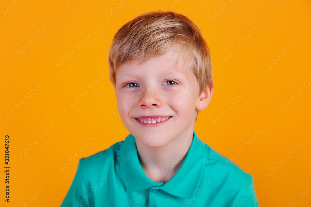 cute adorable schoolboy wearing turquoise t-shirt on yellow background cute adorable schoolboy wearing turquoise t-shirt on yellow background