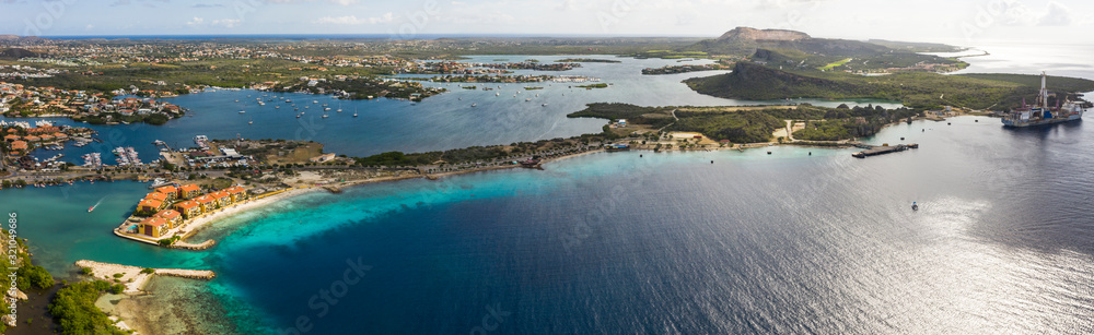 Aerial view of coast of Curaçao in the Caribbean Sea with turquoise water, cliff, beach and beautiful coral reef over Caracas Bay
