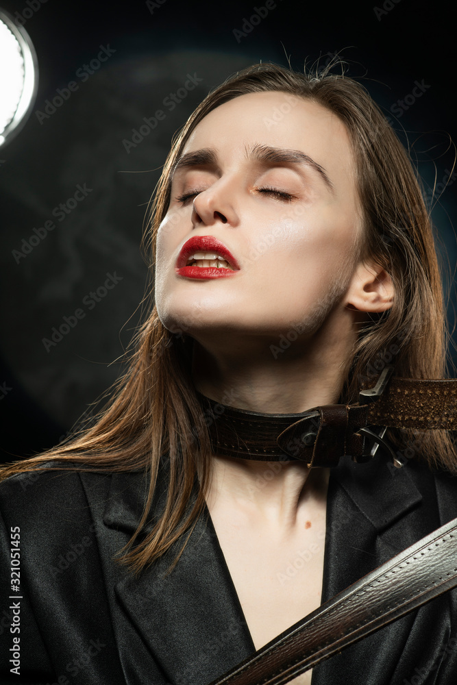 Braless girl with red lips, wearing a black unbuttoned blazer and a men