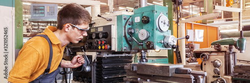 A trainee in the metalworking industry works on a milling machine photo