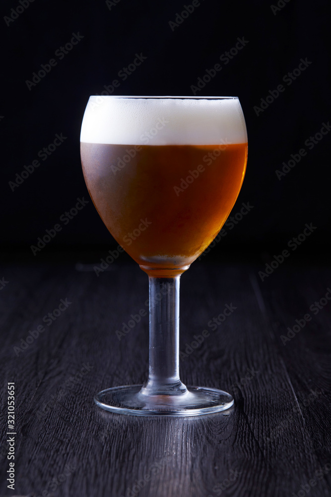 Brown beer texture standing at black background.