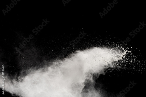 Wybuch proszku białego na białym na czarnym tle. Białe cząsteczki pyłu splash.