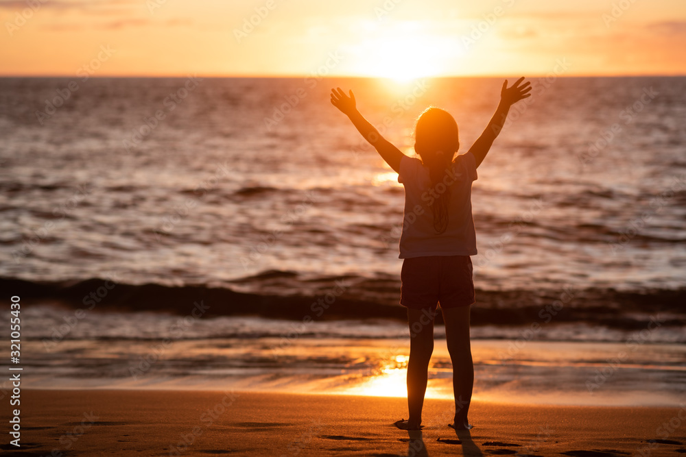Child enjoying the freedom of sunset and sea
