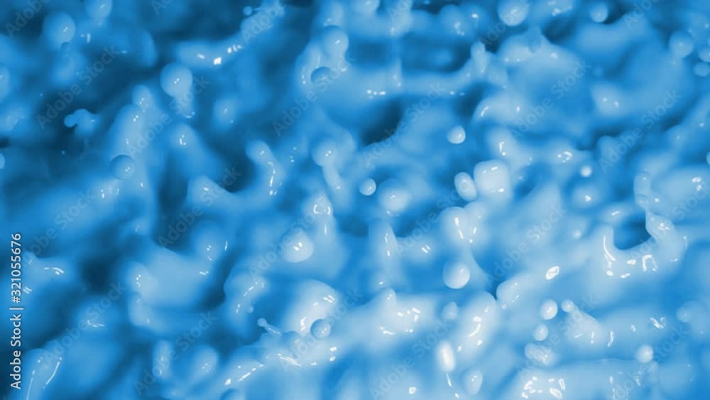 Slow Motion Video: Wave Motion of a viscous fluid surface when excited by vibration. Intense movement of splashes and drops when the surface of the milk is vibrated. Abstract matte blue background Slow Motion Video: Wave Motion of a viscous fluid surface when excited by vibration. Intense movement of splashes and drops when the surface of the milk is vibrated. Abstract matte blue background