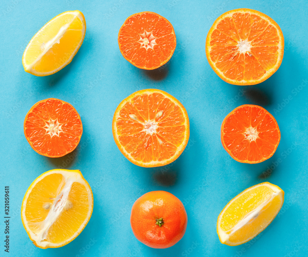 Colorful fruit pattern of fresh citruses on a blue background. Concept orange and lemon flat lay. Colorful fruit pattern of fresh citruses on a blue background. Concept orange and lemon flat lay.