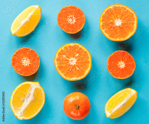 Colorful fruit pattern of fresh citruses on a blue background. Concept orange and lemon flat lay.