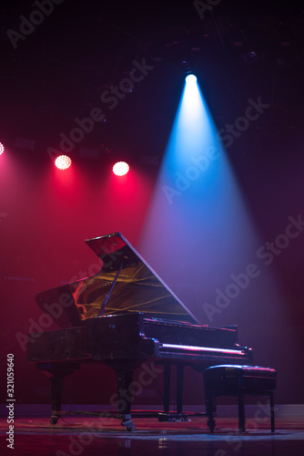 the piano on stage in the spotlight.