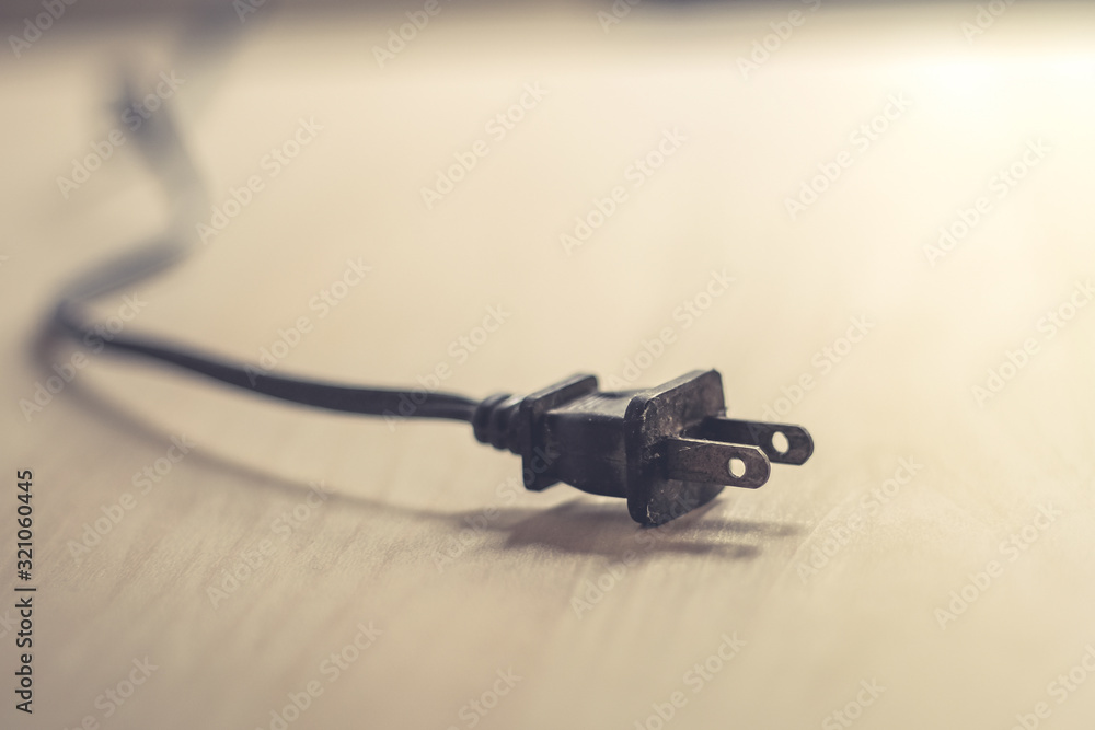 Close up of an electrical plug on wood table Close up of an electrical plug on wood table