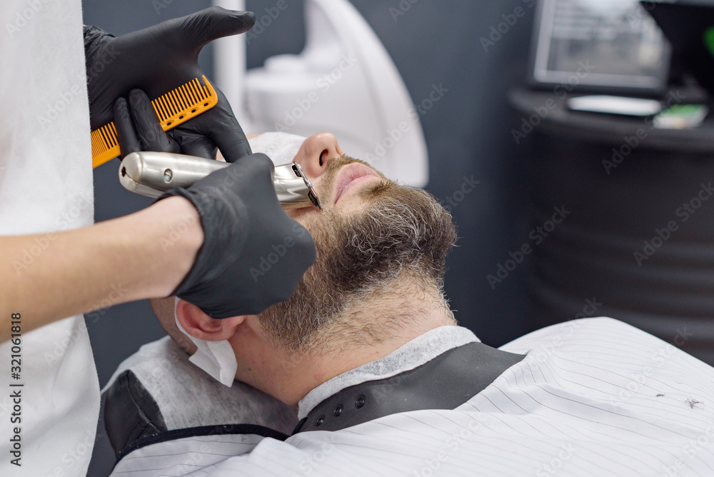 Fototapeta premium beard modeling in Barber shop, beard care for men, male beauty concept