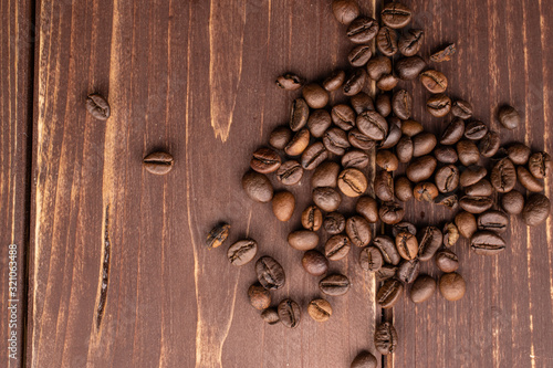 Lot of whole fresh coffee bean flatlay on brown wood © PIXbank