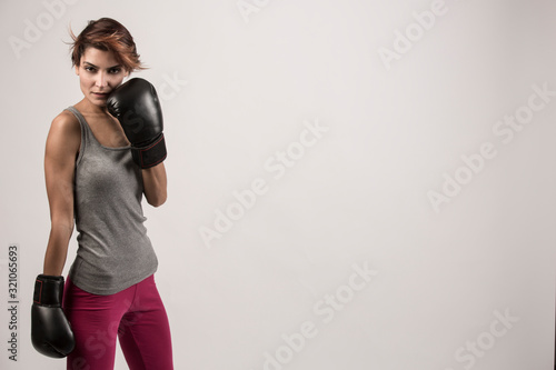 donna  con i guantoni da boxe isolata su sfondo grigio chiaro © alex.pin