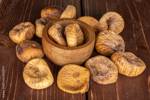 Lot of whole dried fig on brown wood