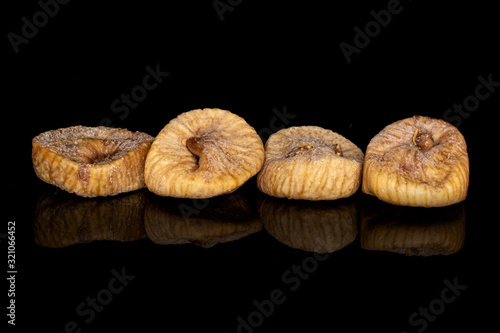 Group of four whole dried fig isolated on black glass